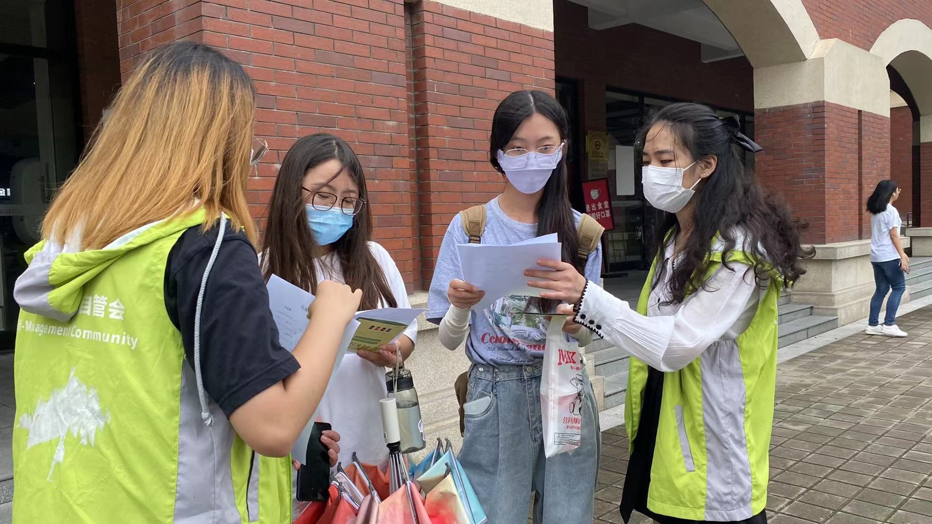 4.上海建桥学院垃圾分类志愿者在分发宣传单并讲解垃圾分类知识.jpg