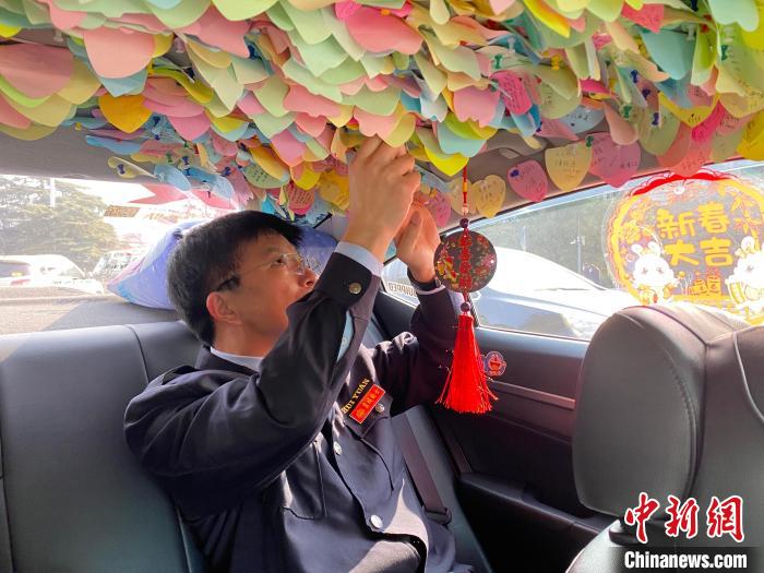 出租车司机周文昌整理车内便利贴。 李明芮 摄