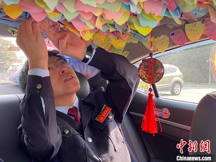 出租车司机周文昌整理车内便利贴。 李明芮 摄